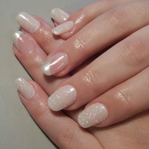 Short rounded nails in sparkling white with pearl chrome French tips