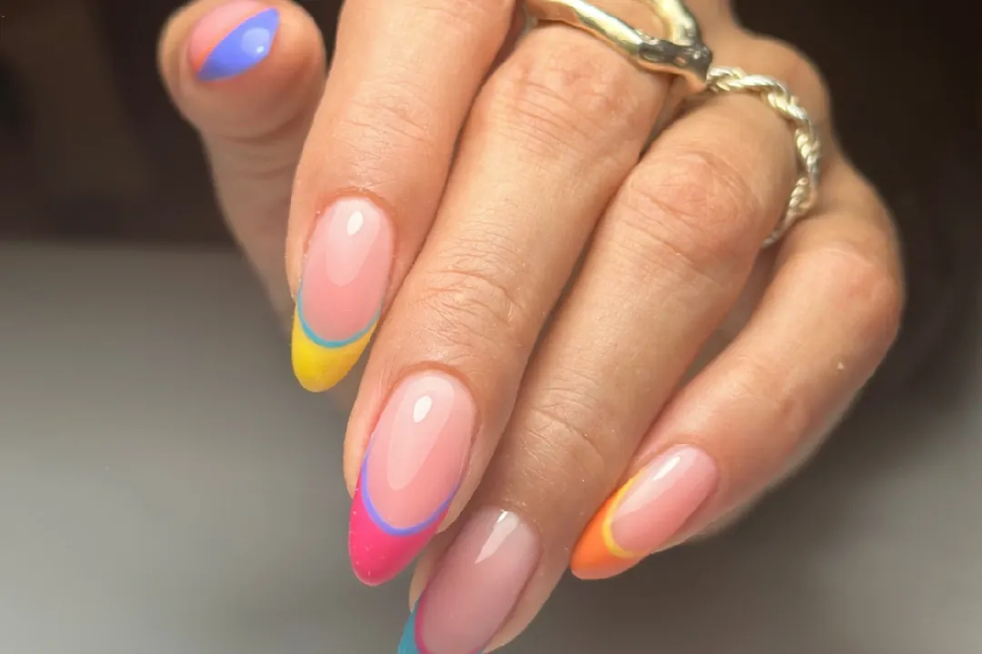 Long almond nails with a sheer pink base and multicolor French tips