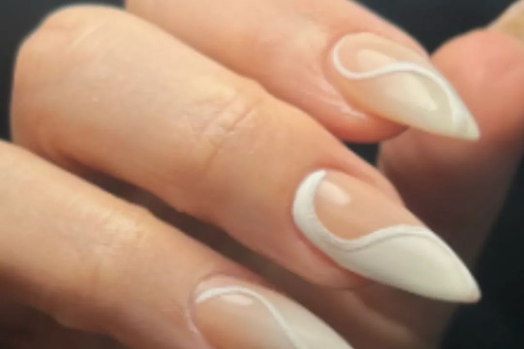 Long almond acrylic nails with a sheer nude base and white swirl line art