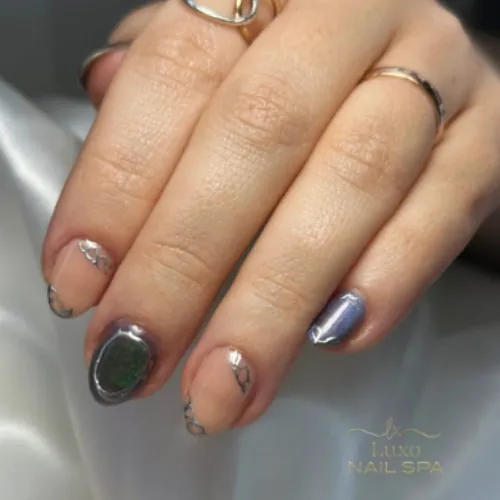 Short builder gel manicure with chrome edge details and a dark cat-eye accent nail
