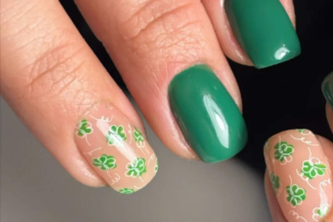 Short square nails in glossy green gel with clover accent art