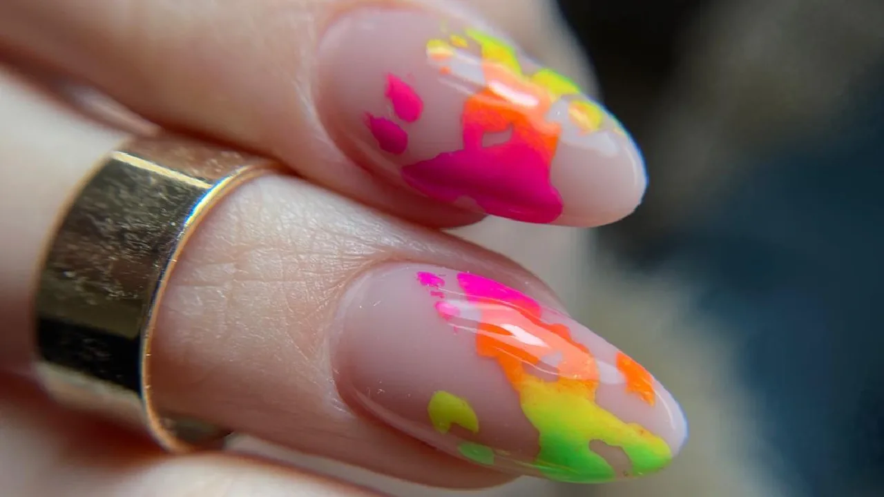 Nude almond nails with neon paint splatter