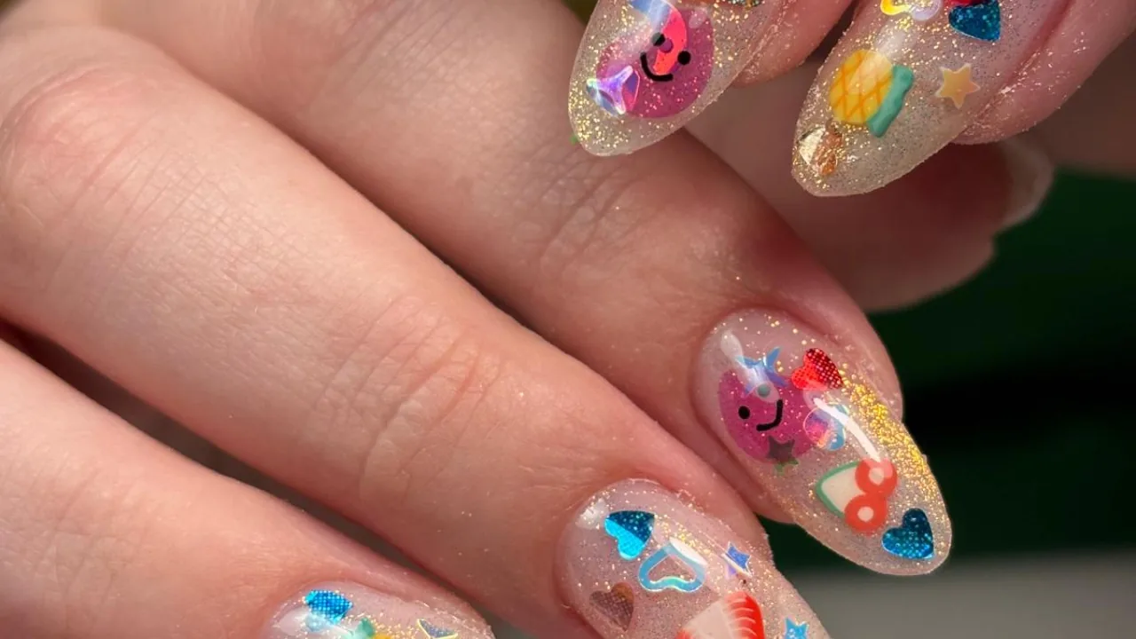 Glitter nails with playful cartoon face art