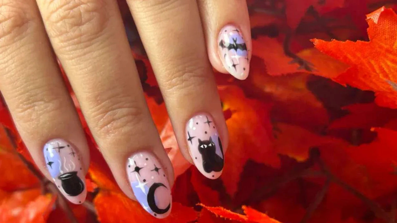 Pale pink Halloween nails with black cats and moons