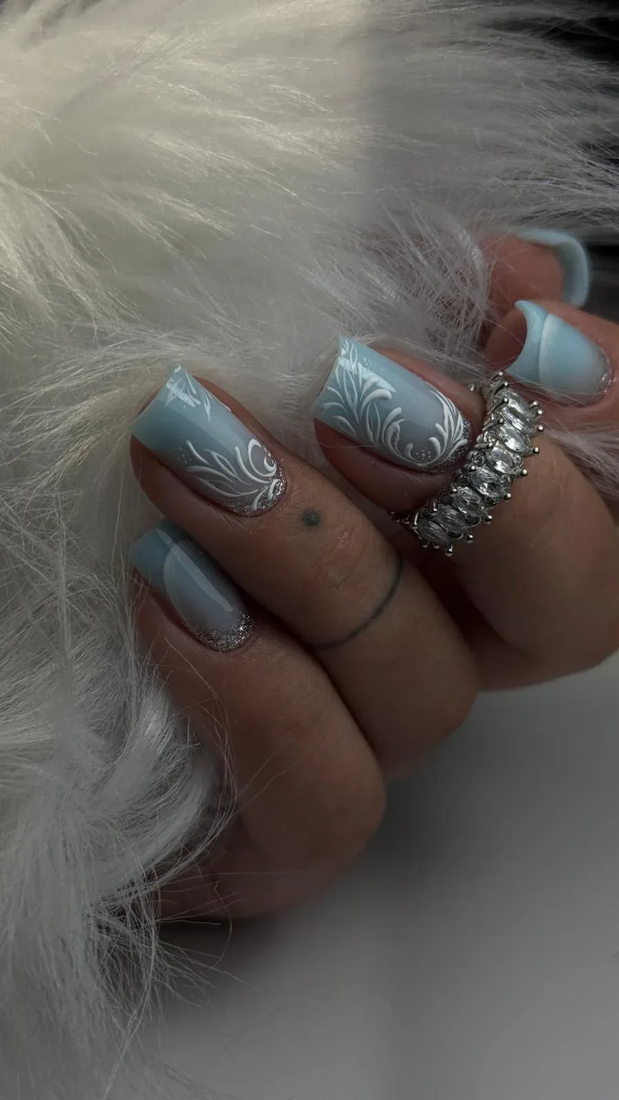 Icy blue nails with silver glitter accents