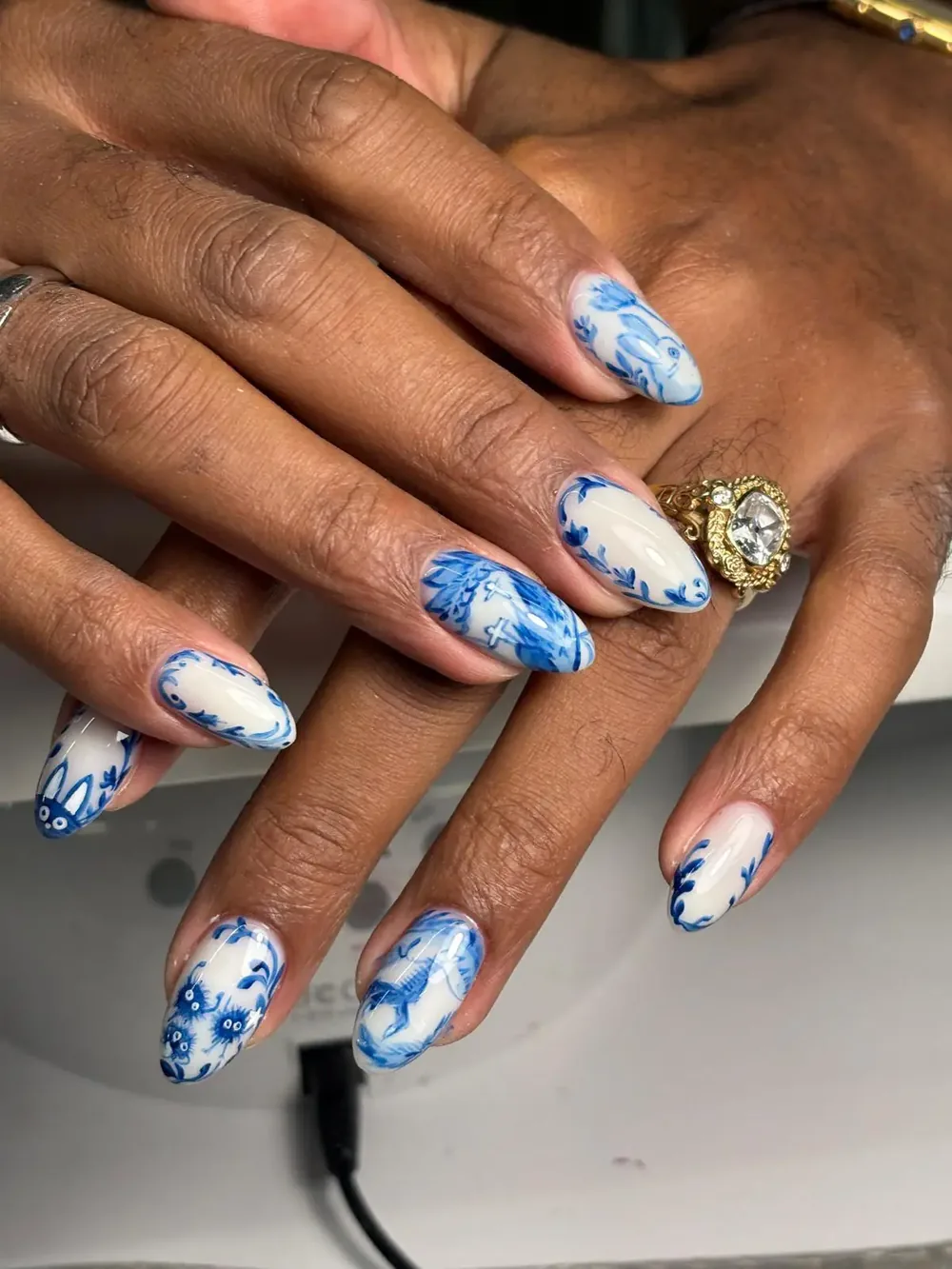 Blue floral art on white nails